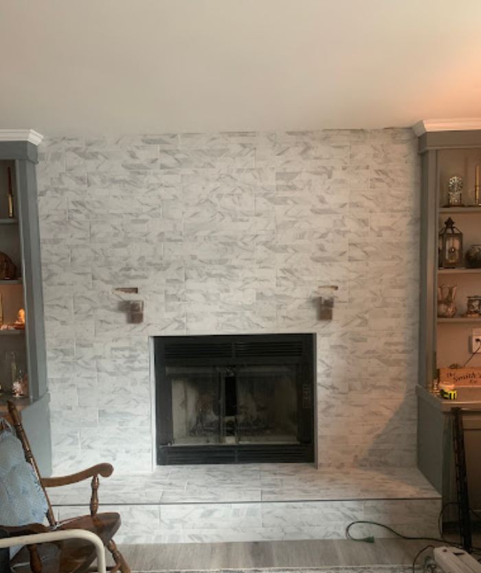 A living room with a fireplace and a rocking chair.