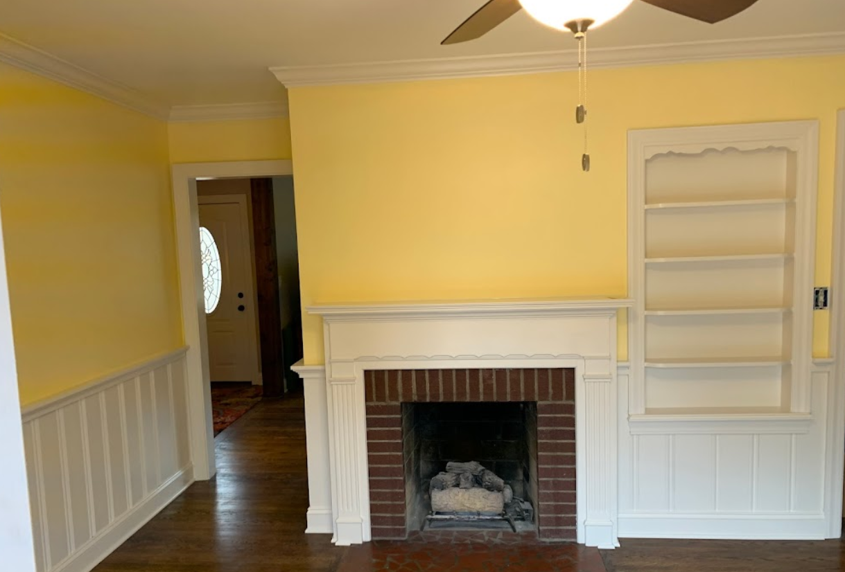 A living room with a fireplace and a ceiling fan