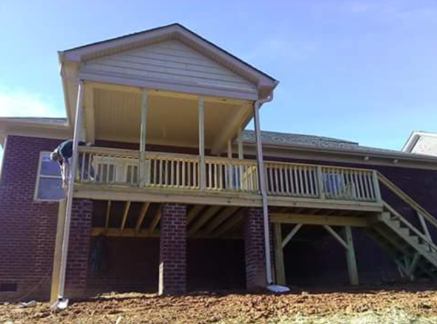 A brick house with a wooden deck underneath it