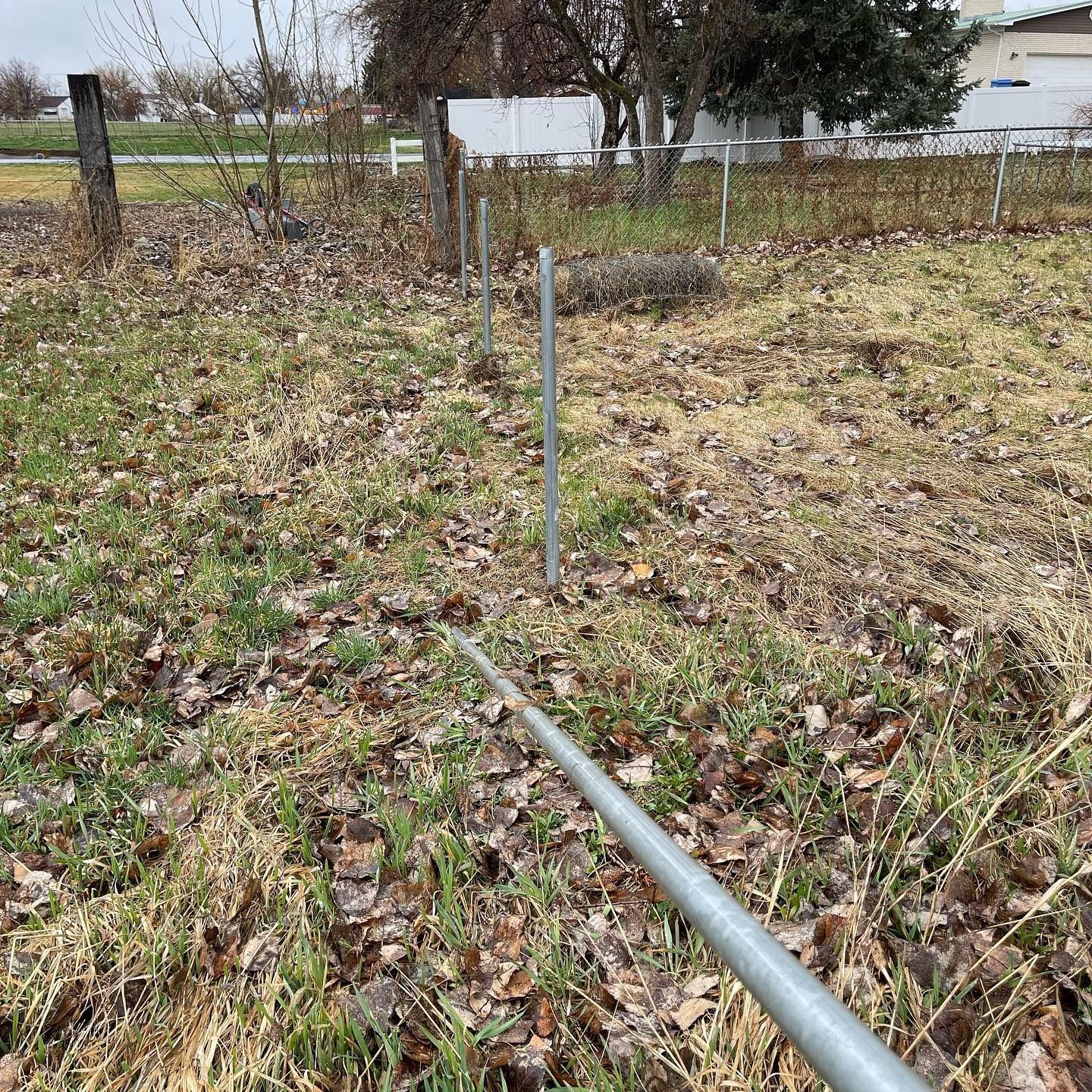 A metal pole is sitting in the middle of a grassy field.