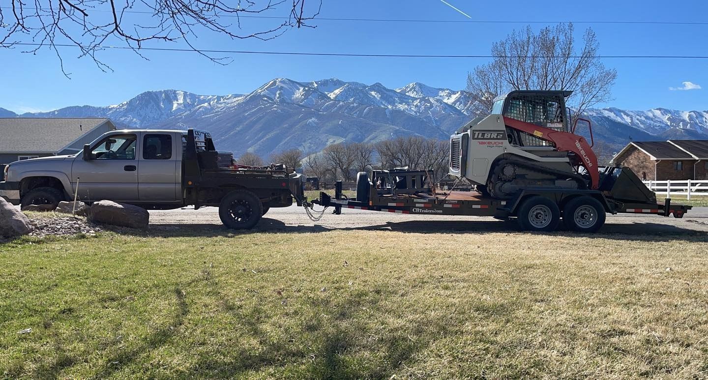 A truck is towing a bulldozer on a trailer.