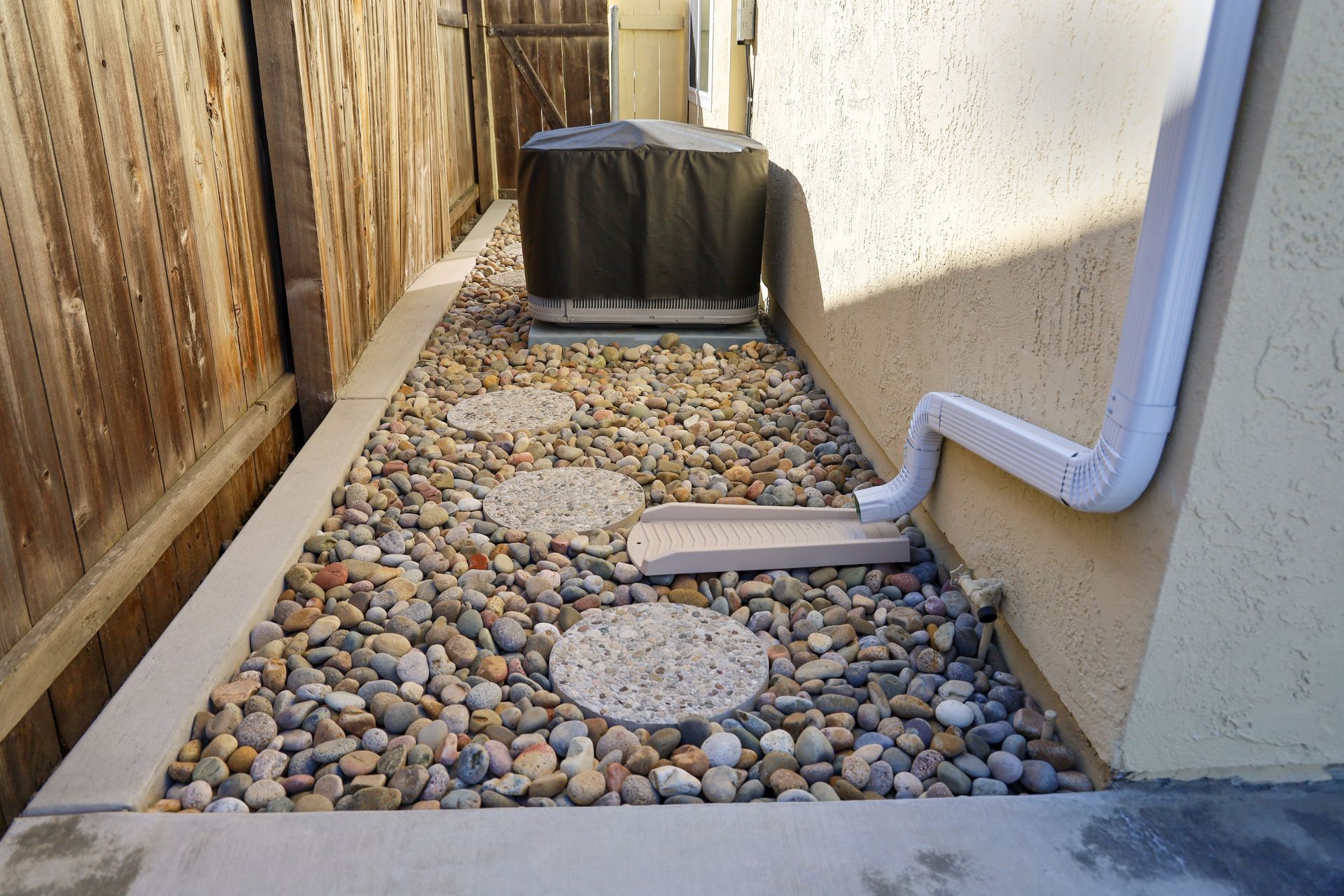 A walkway with rocks on the side of a house