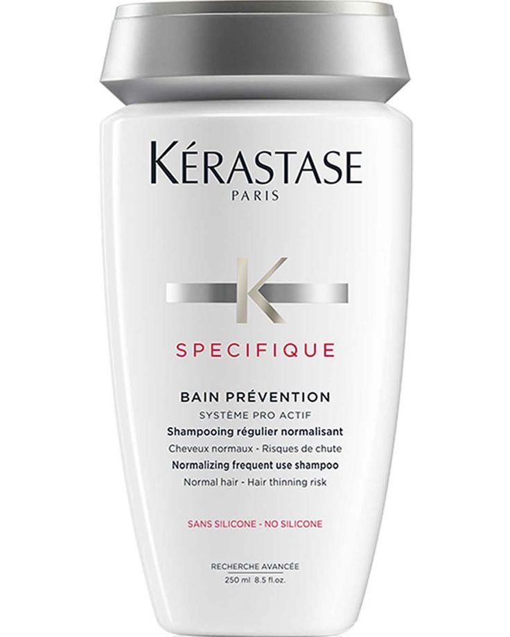 Una botella de champú Kerastase Specifique Bain Prevention sobre un fondo blanco.