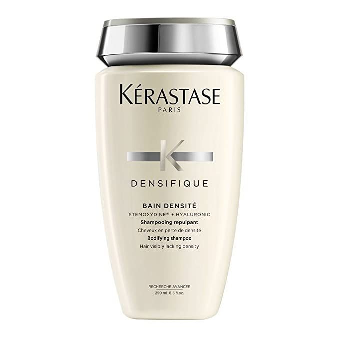 Una botella de champú Kerastase Densifique sobre un fondo blanco.