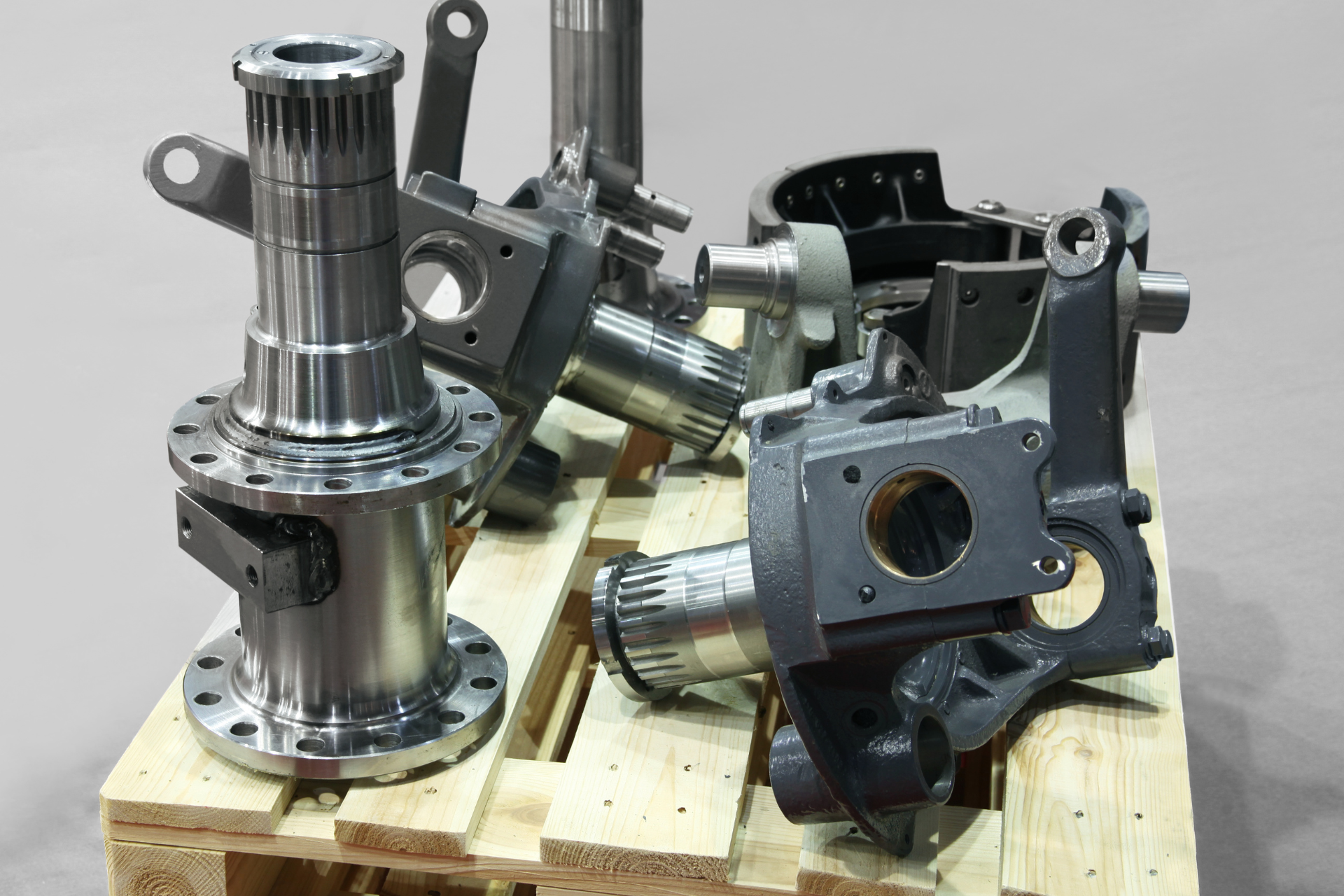 A bunch of metal parts are sitting on top of a wooden pallet.