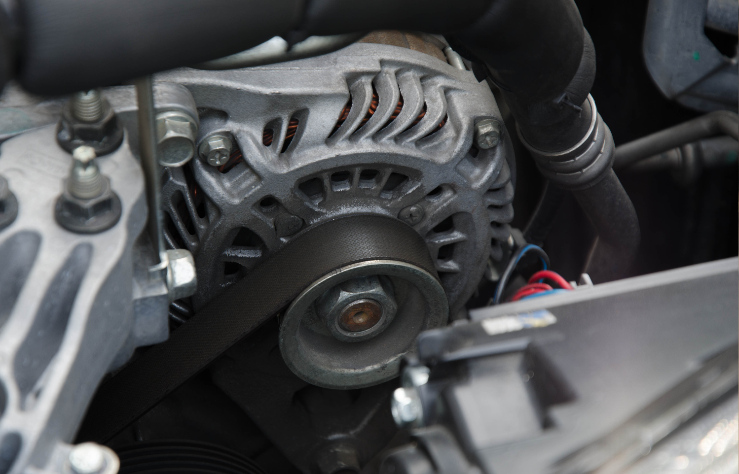 A close up of a car engine with the hood open