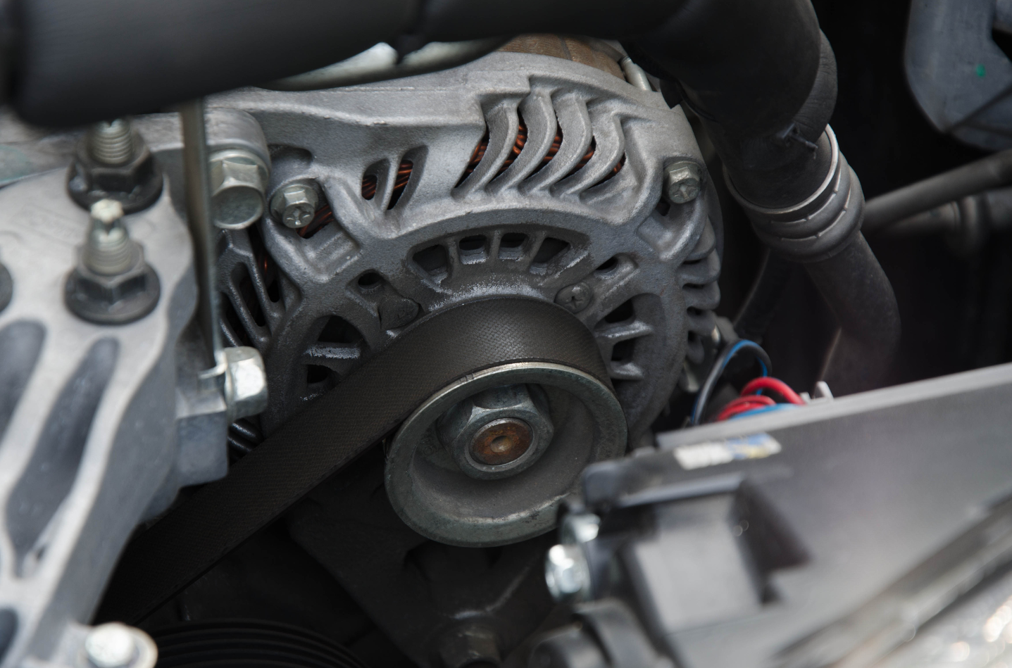 A close up of a car engine with the hood open
