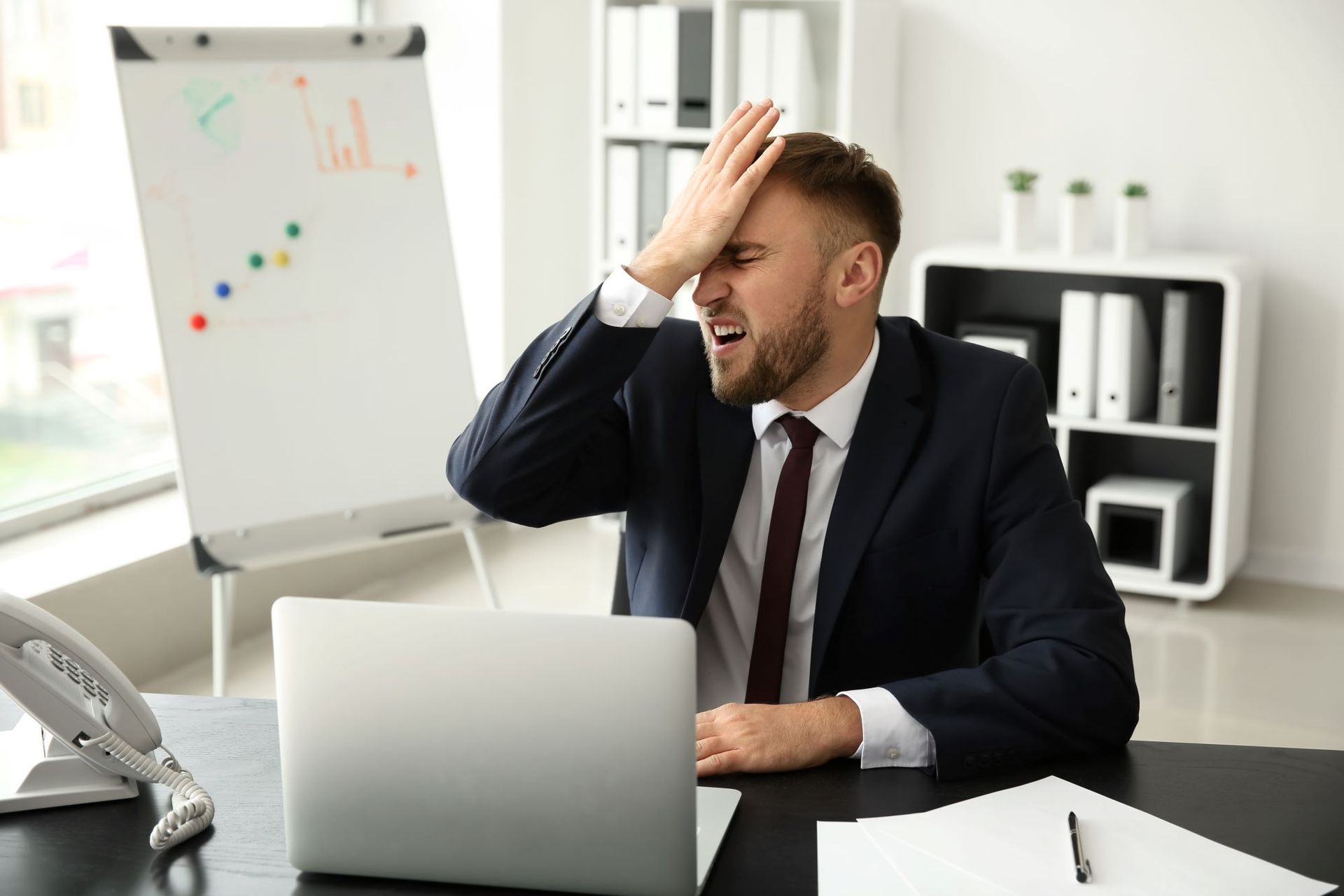 Business man smacking his forehead after making a mistake