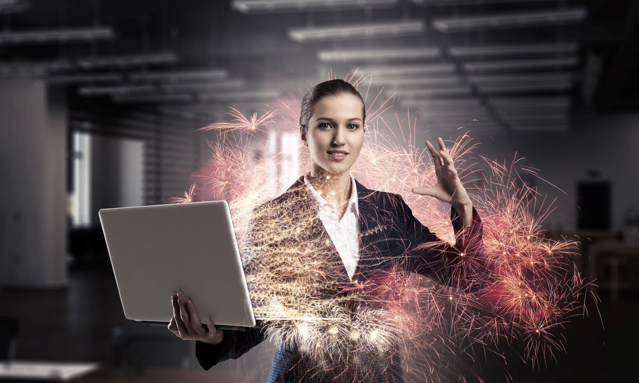 Business woman with magic powers holding a laptop