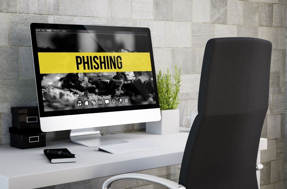 Computer screen on a  the word 'Phishing' written across the monitor