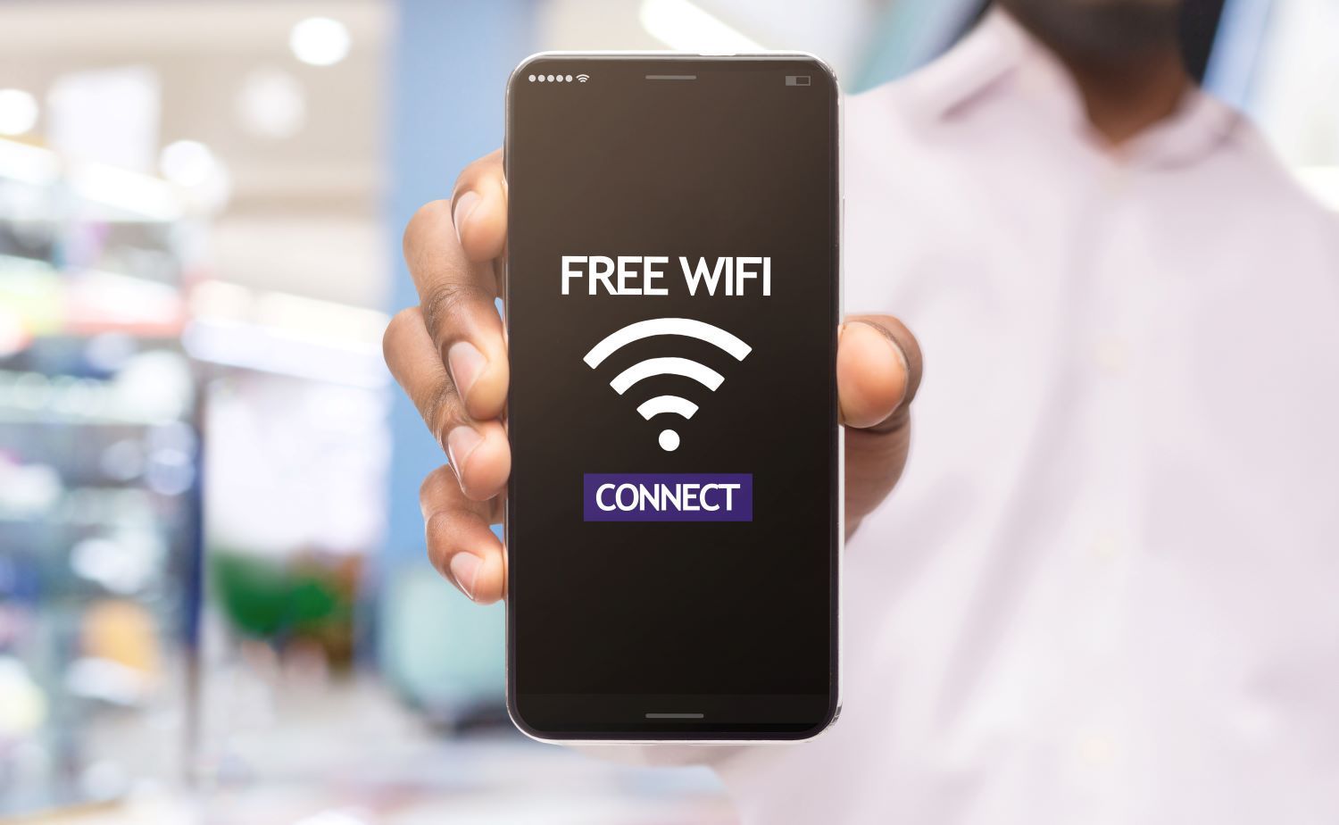 Man holding out a phone with 'FREE WiFi' displayed on the screen