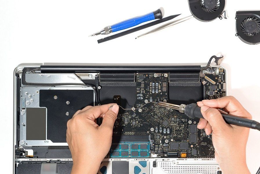 Person repairing a laptop using specialist tools