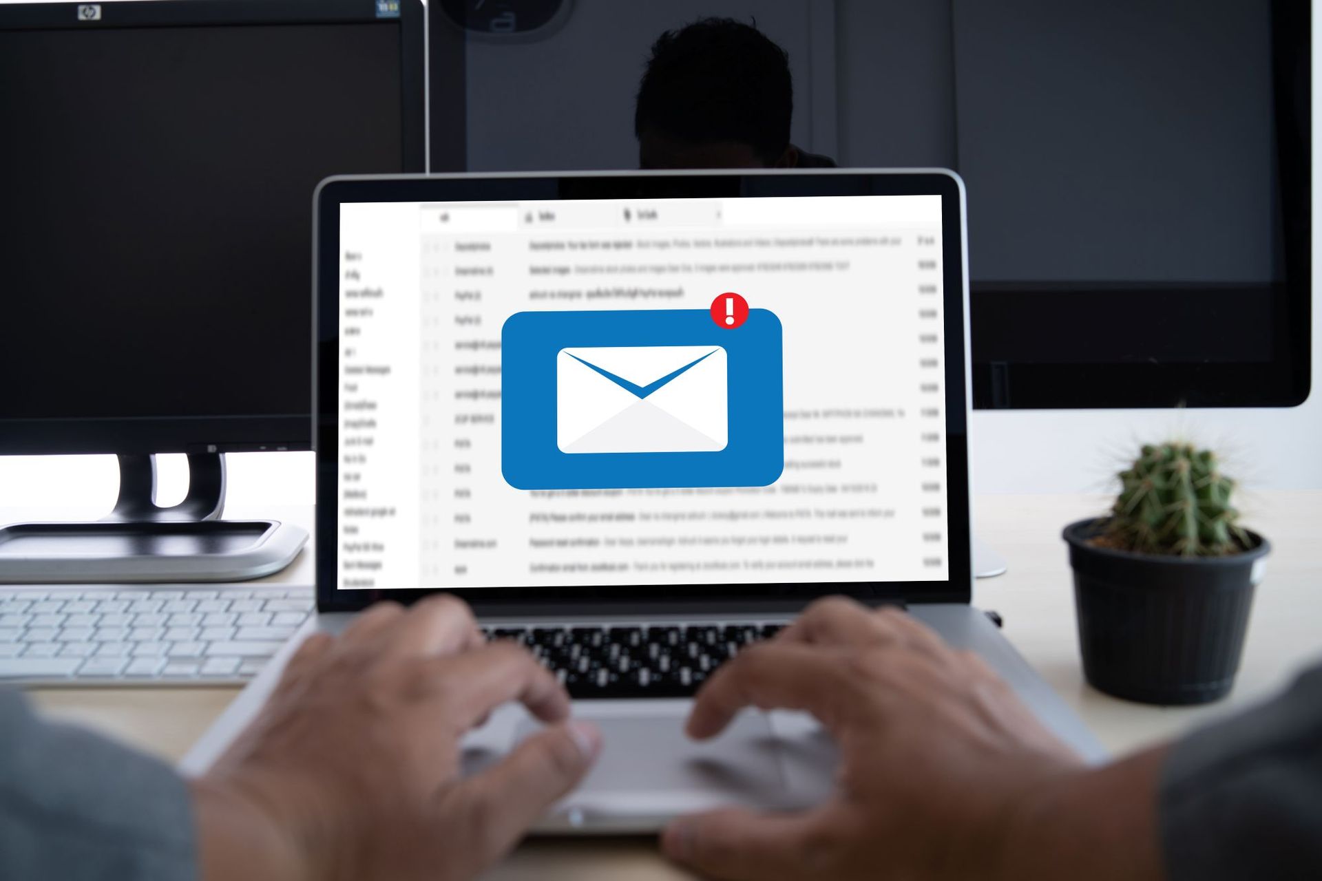 Person in front of a laptop looking at their emails with a symbol showing one new email