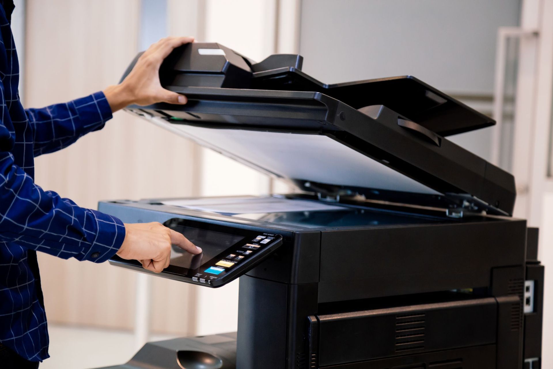 Someone making a photocopy of a document on a multipurpose printer