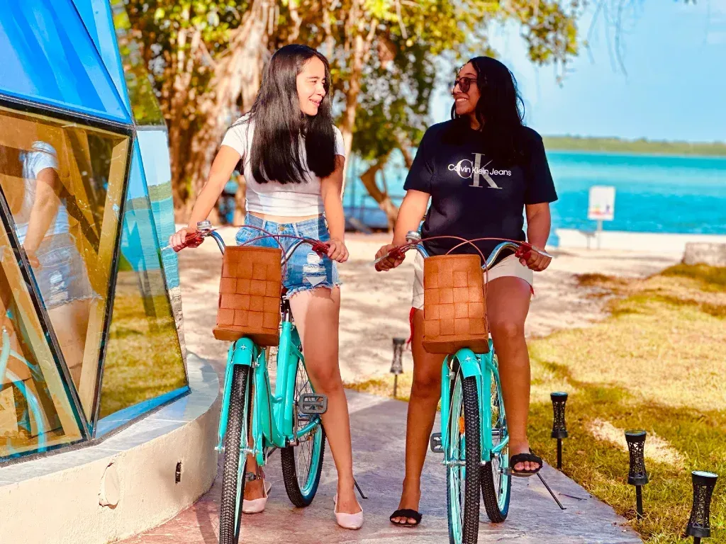 Un grupo de personas está sentada en el suelo viendo una película en una pantalla de proyector.