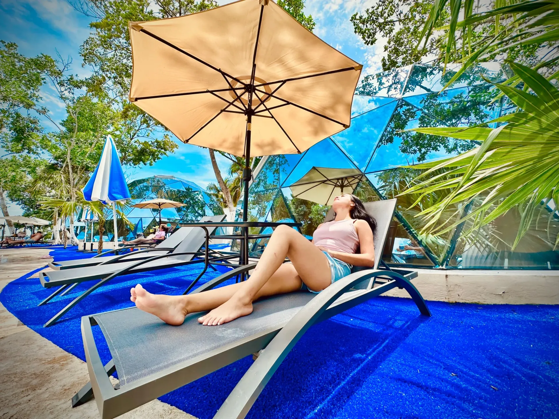 Un grupo de personas está sentada en el suelo viendo una película en una pantalla de proyector.