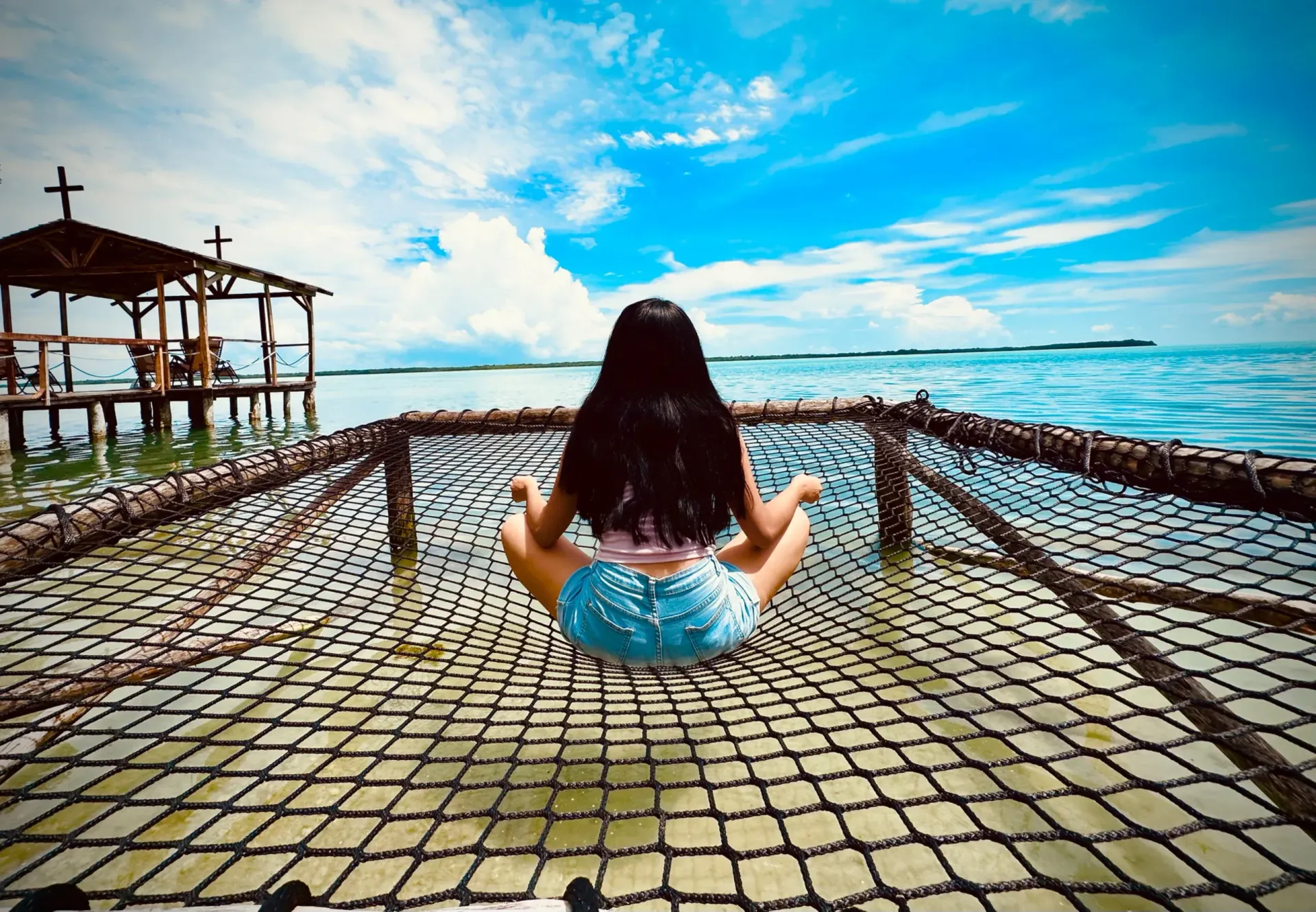 Una larga mesa de madera con platos y vasos encima.