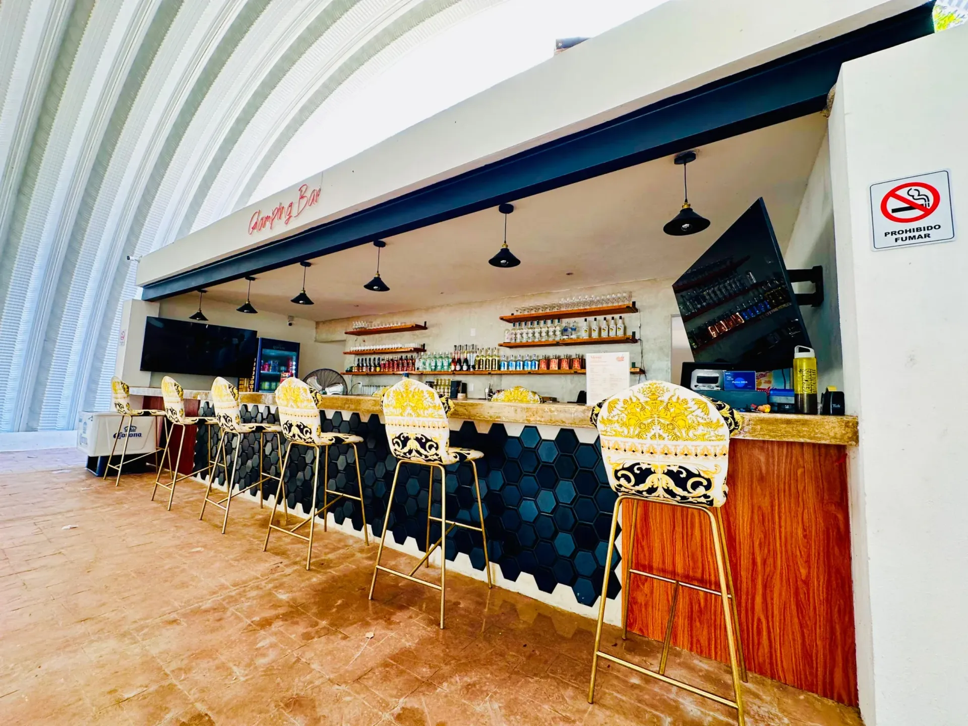 Bar con taburetes. Azulejos hexagonales azul oscuro, mostrador de madera y palomitas de maíz.