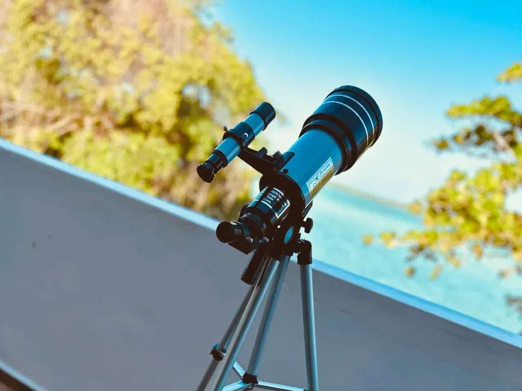 Un grupo de personas está sentada en el suelo viendo una película en una pantalla de proyector.