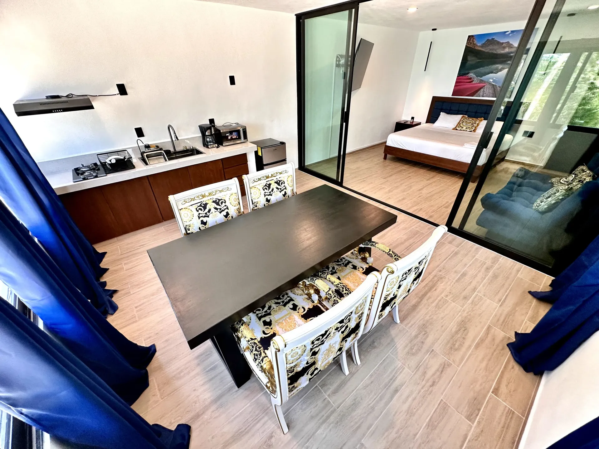 Interior de una cocina moderna, comedor y dormitorio con paredes de cristal.