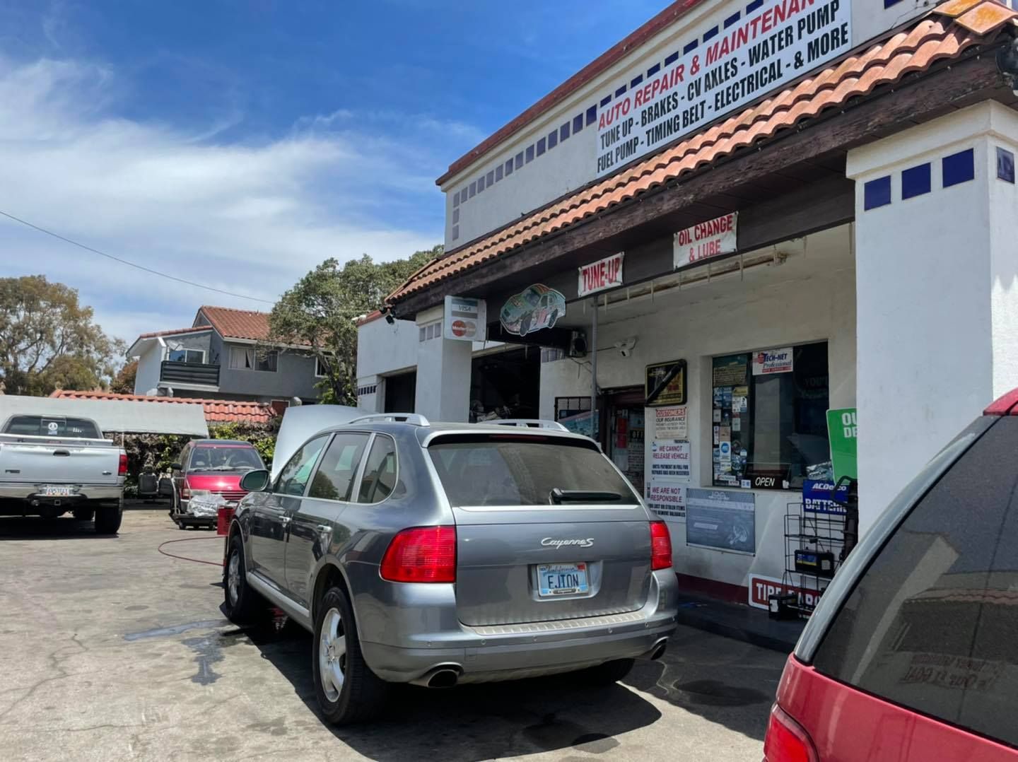 A silver car is parked in front of a building.
