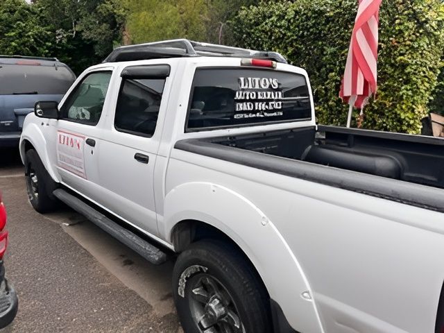 A white truck with lito 's auto repair written on the back window