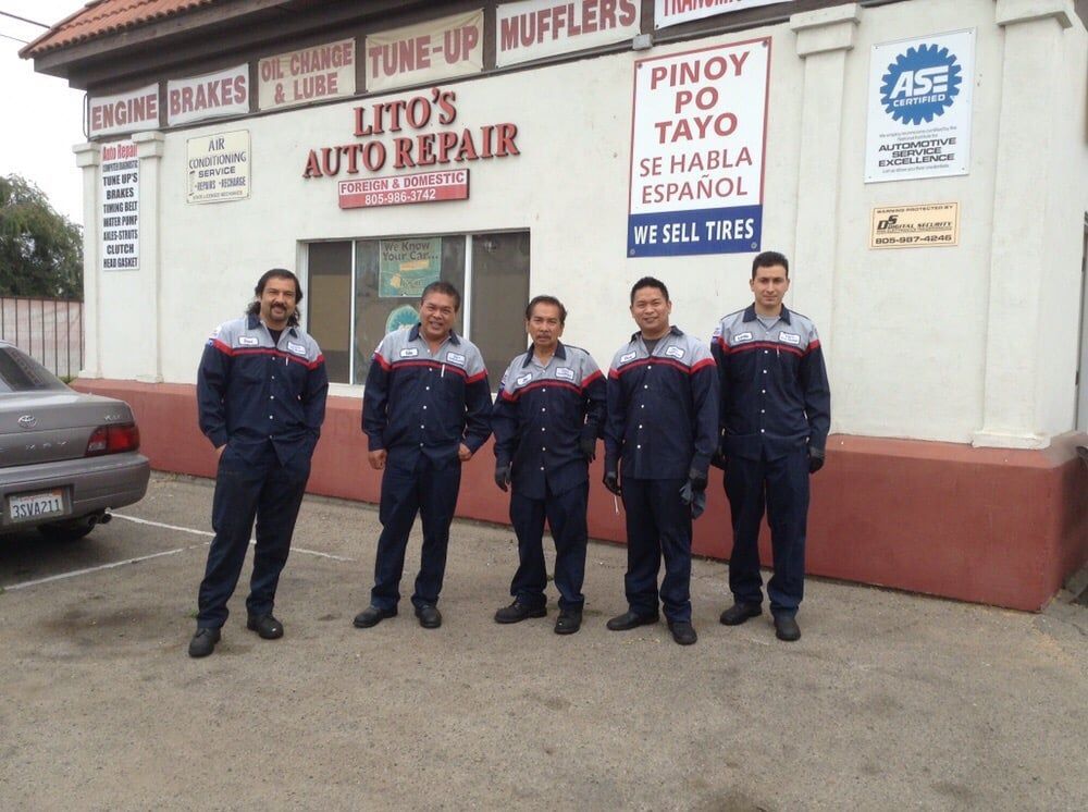 A group of men standing in front of lito 's auto repair