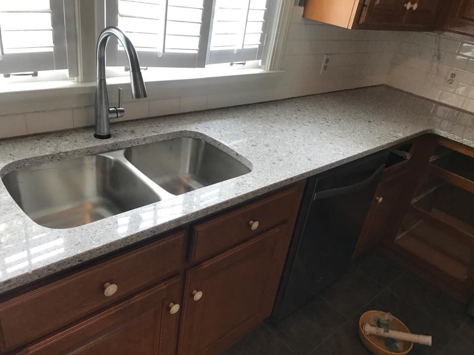 A kitchen with a stainless steel sink and a dishwasher.