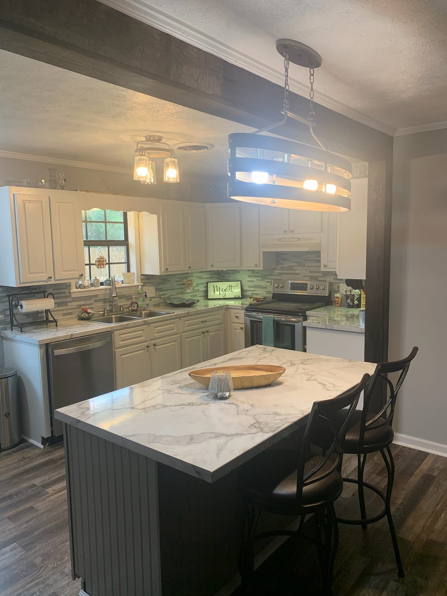 A kitchen with a table and chairs and a marble counter top.