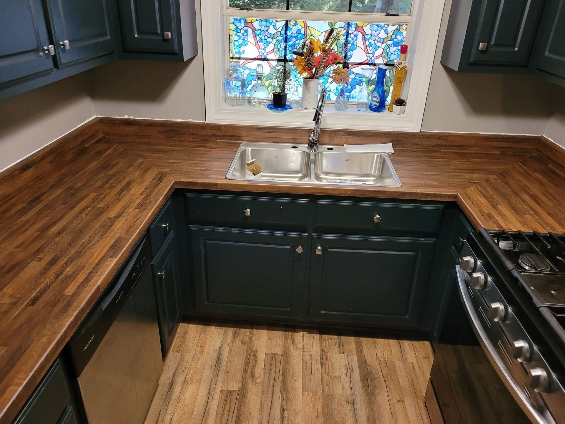 A kitchen with a sink , stove and dishwasher