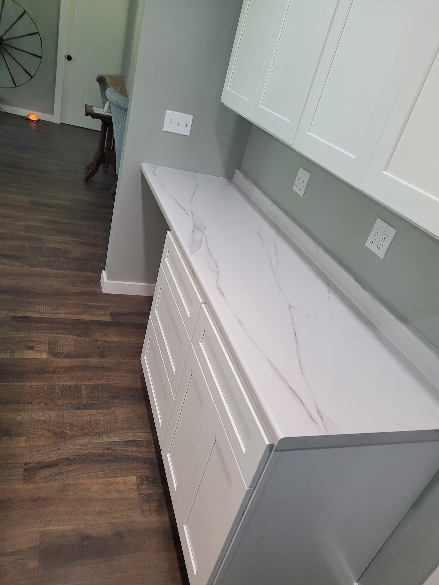A kitchen with white cabinets and a white counter top.