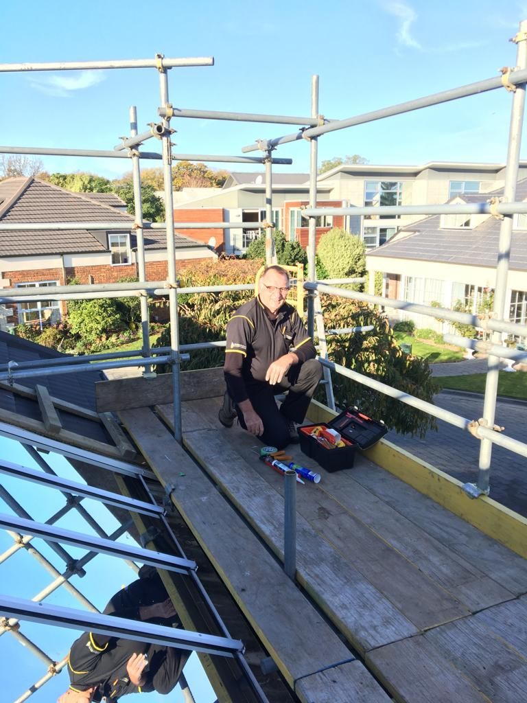 A man is sitting on a scaffolding - Christchurch, NZ - Tint A Window