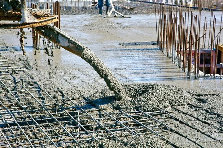 A concrete pump is pouring concrete on a construction site.