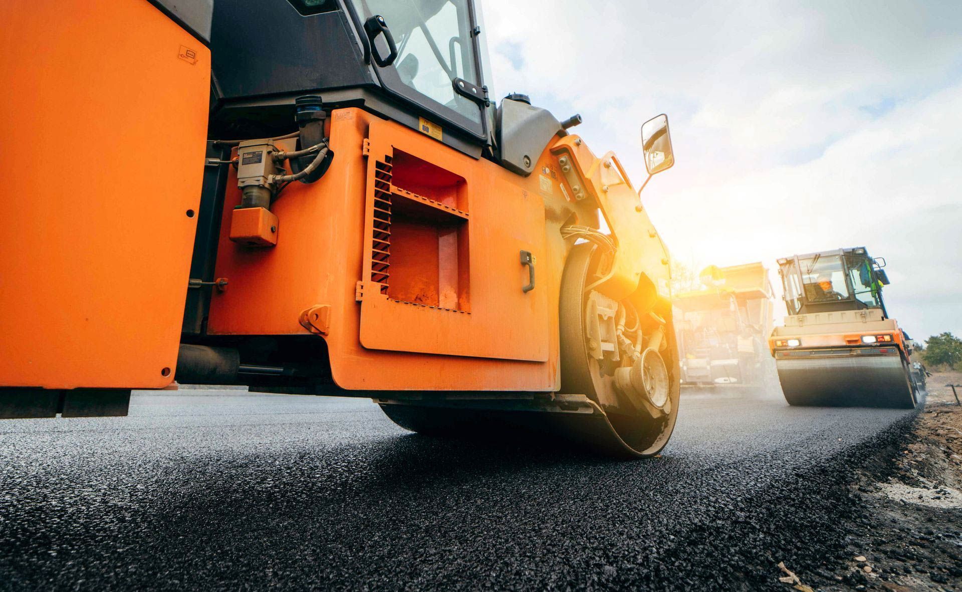 A roller is rolling asphalt on a road under construction.