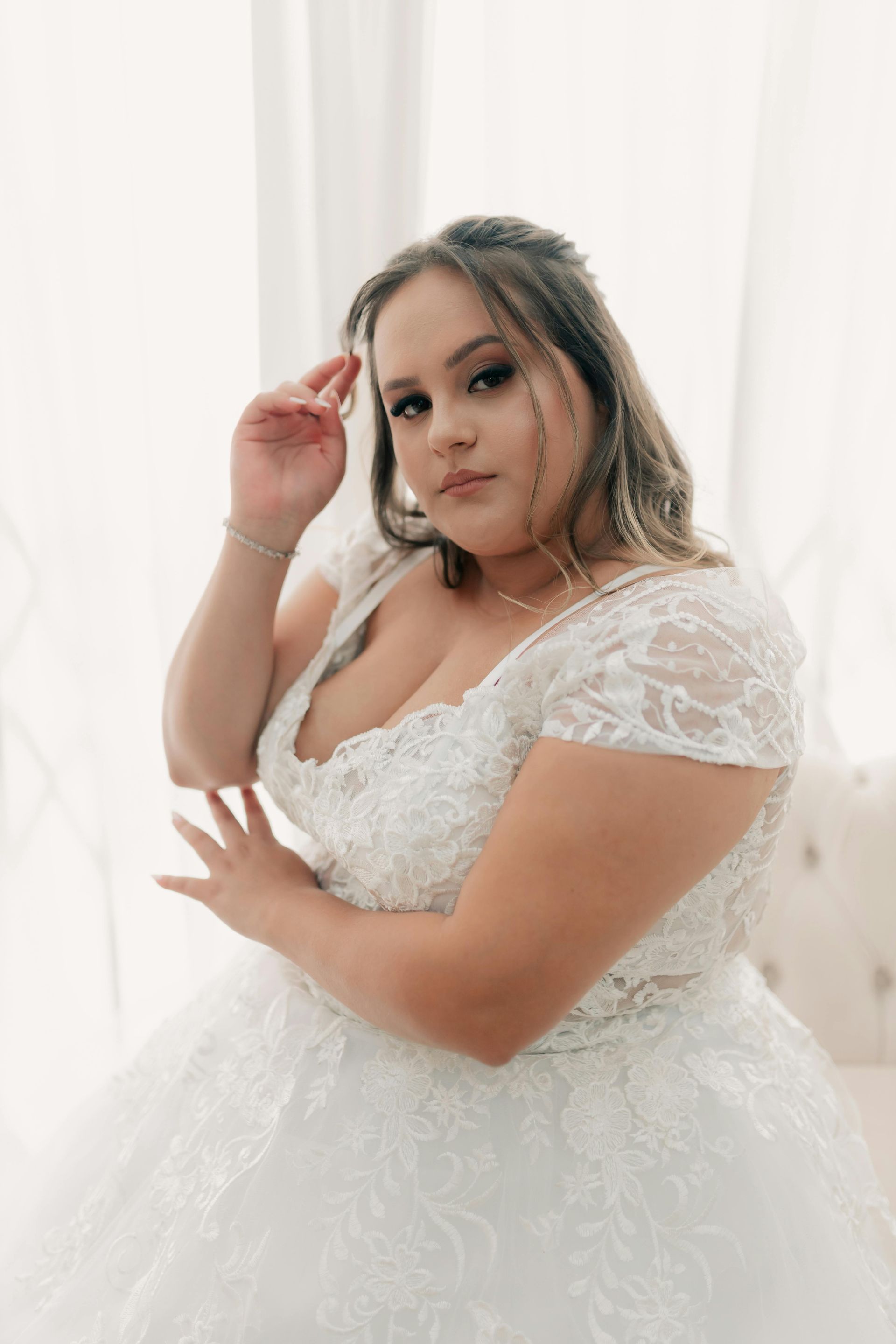 Woman in a white lace wedding dress laughing joyfully.