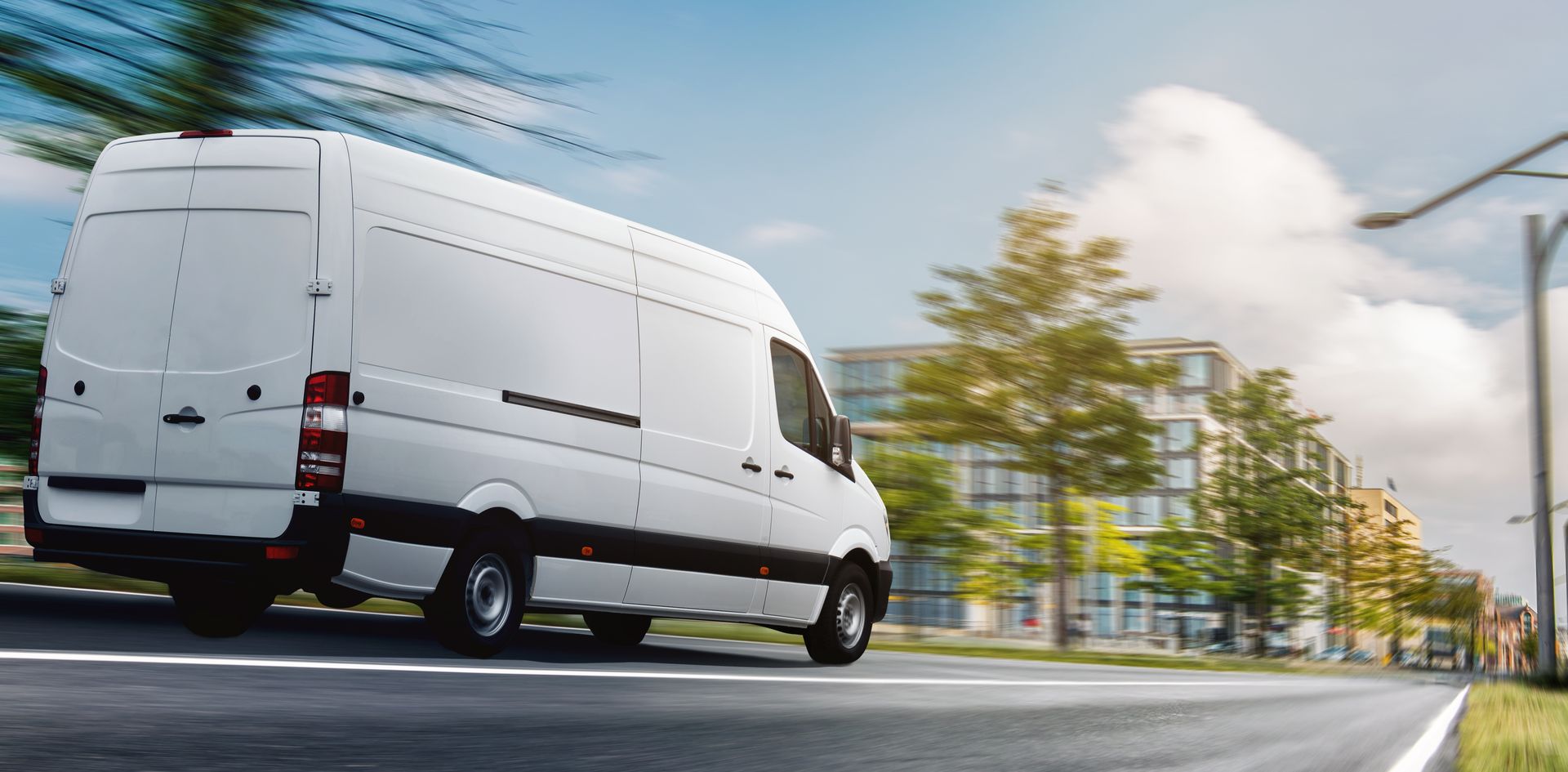 A white van is driving down a city street.