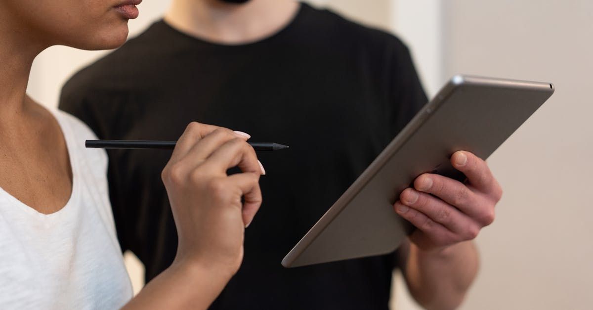 A man and a woman are looking at a tablet together.