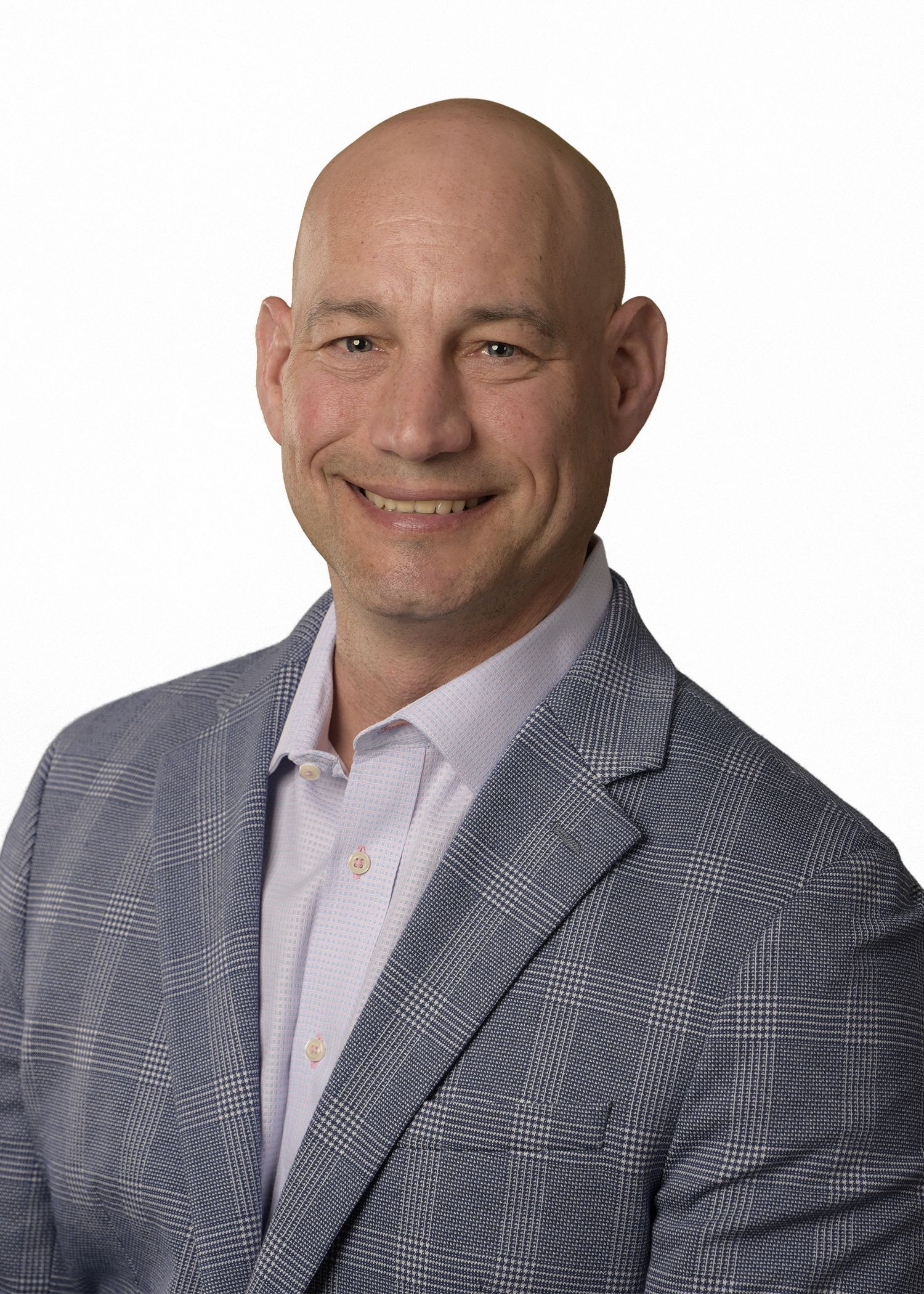 A man in a suit and tie is smiling for the camera