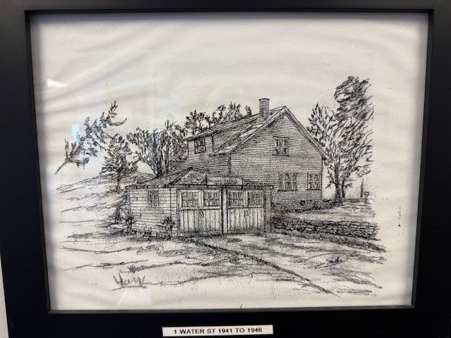 A black and white drawing of a house in a frame.