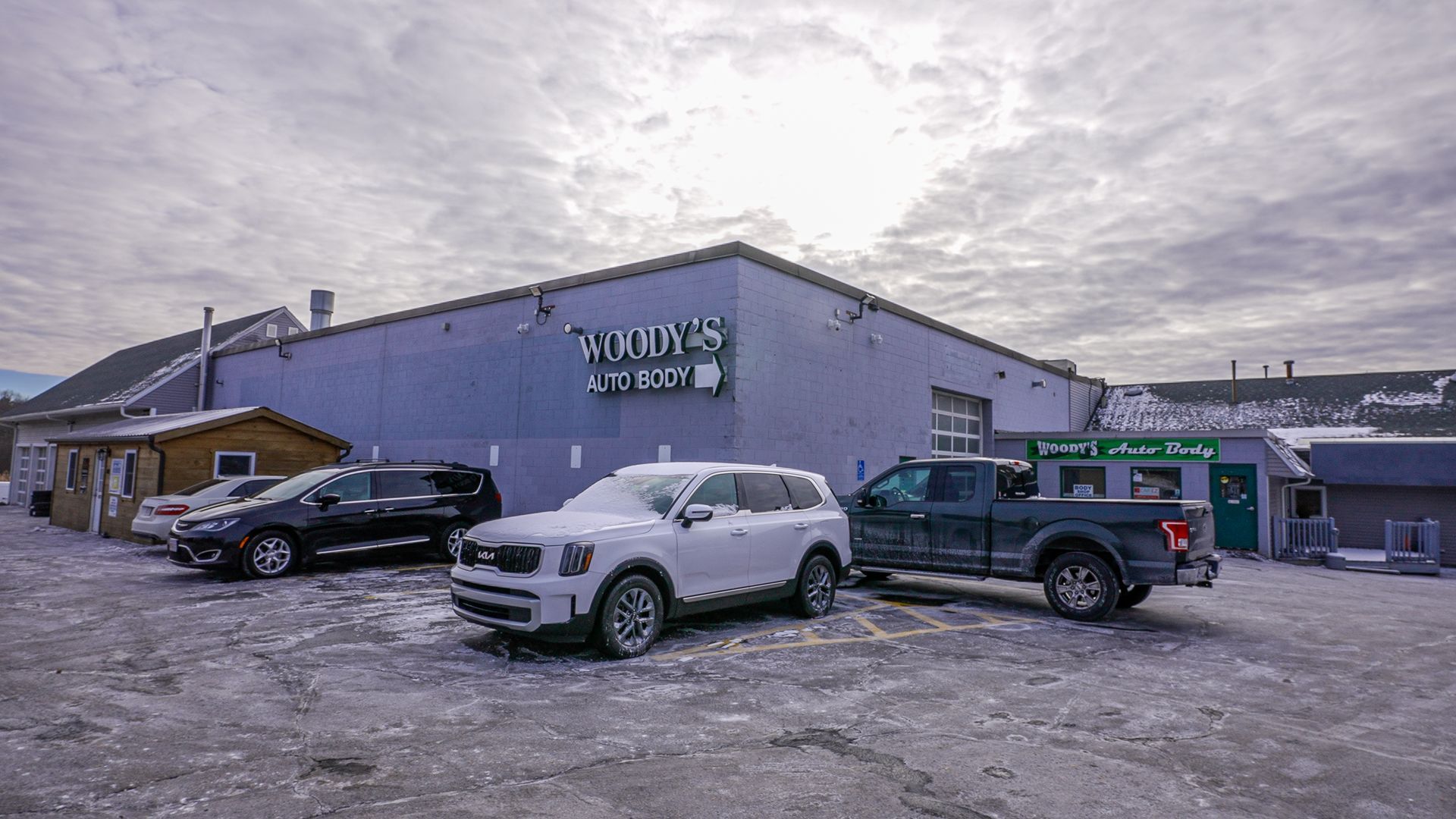 A group of cars are parked in front of a building.