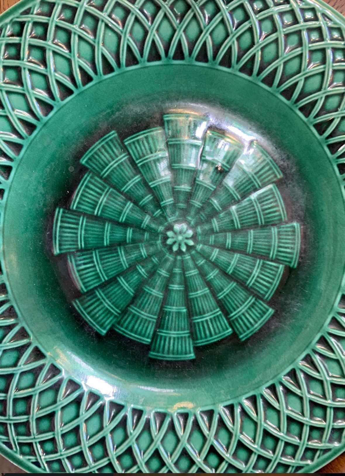 Green abstract circular geometric pattern with a woven lattice and central radial design