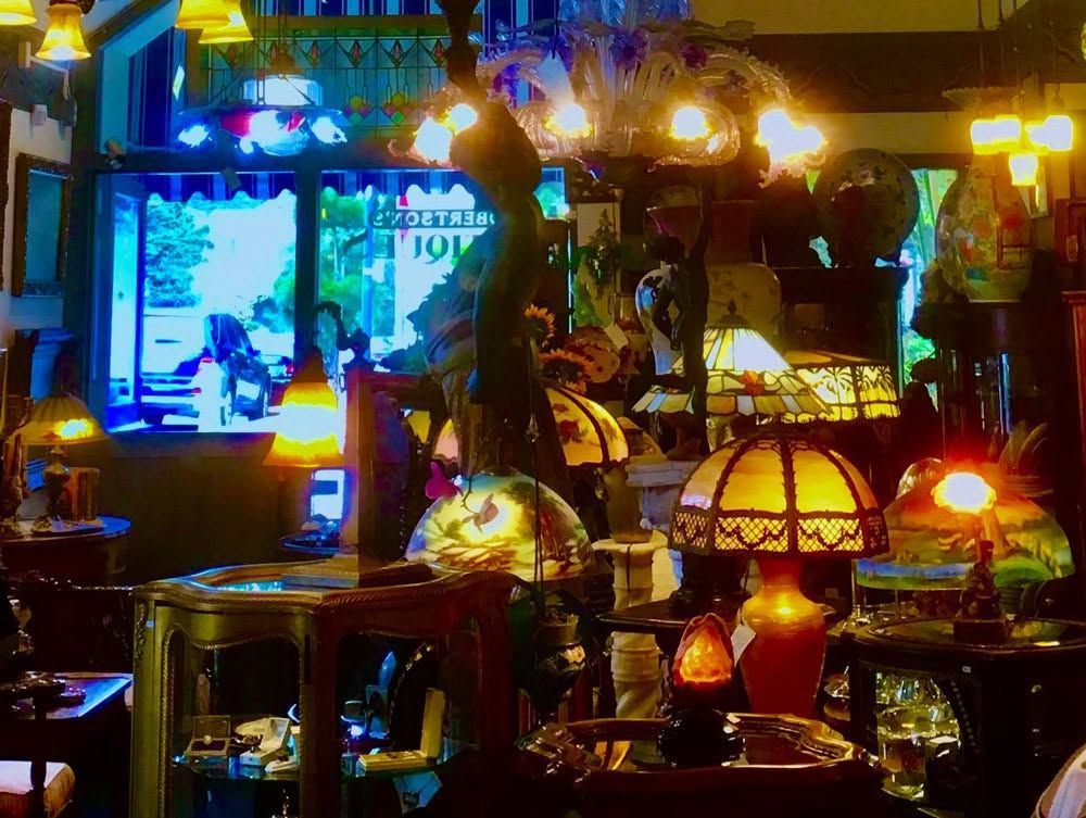Cozy bar interior with warm hanging lamps, stained-glass shades, and colorful reflections on glass surfaces