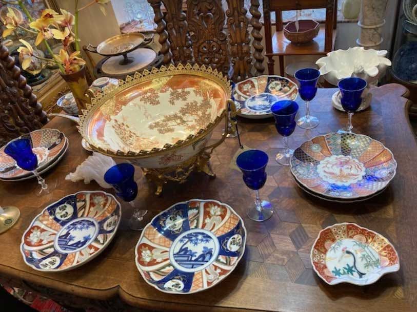 Blue and white ceramic dishes and cups arranged on a dining table with a large decorative serving bowl