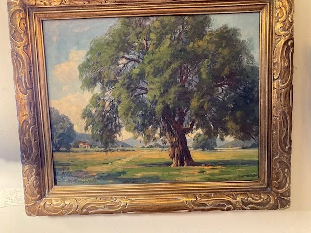 Framed landscape painting of a large tree in a grassy field under a blue sky
