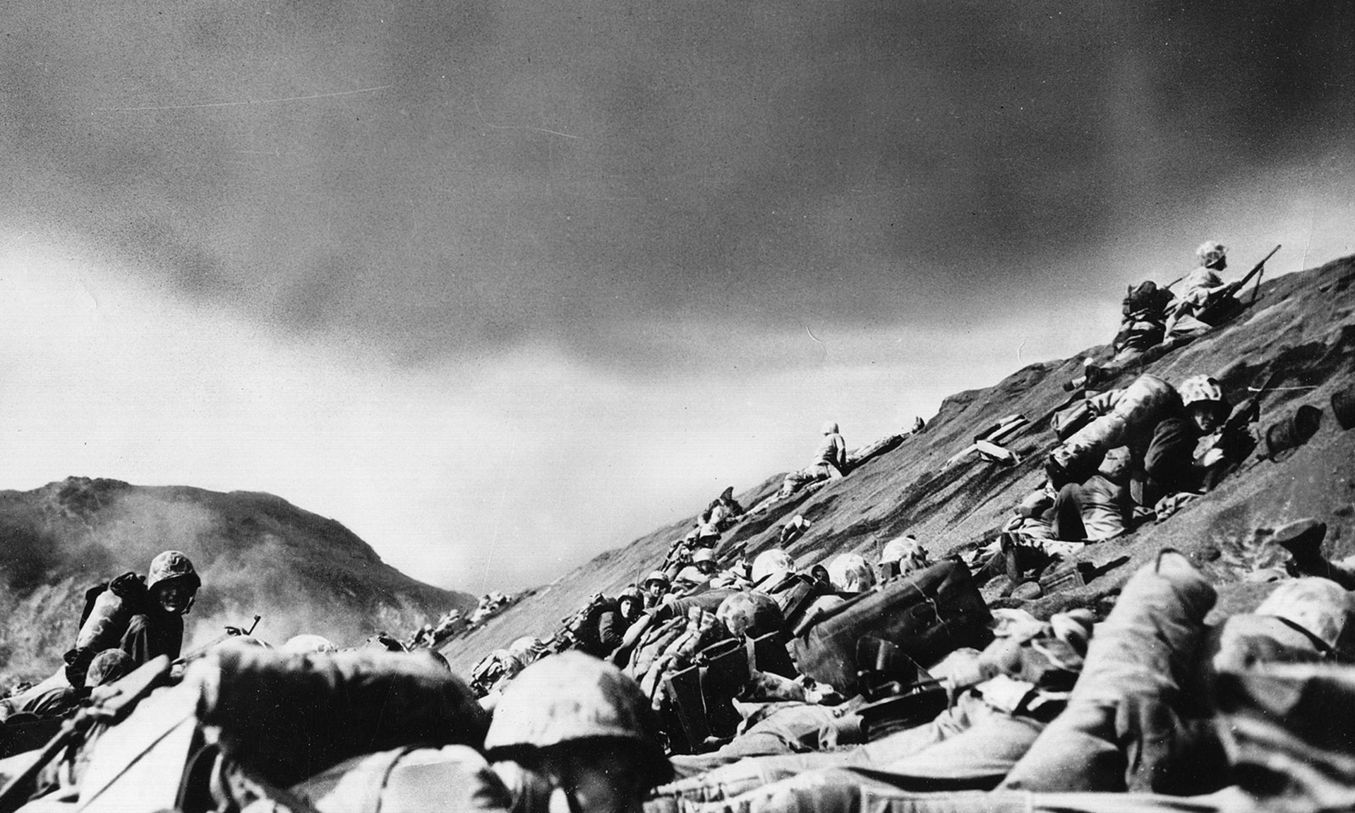 a black and white photo of soldiers on a hill