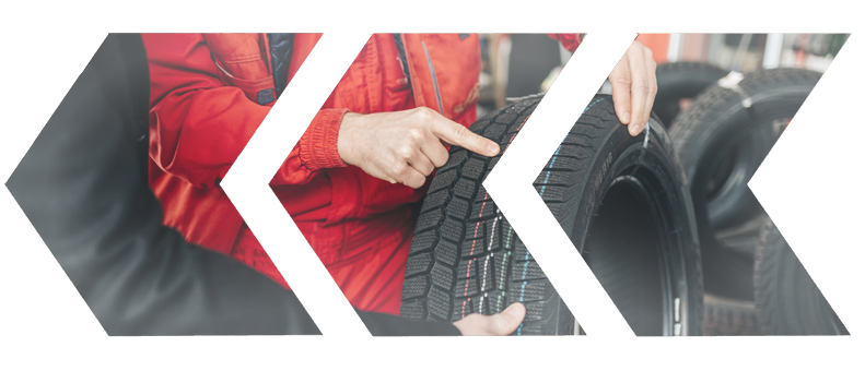 A person in a red jacket is pointing at a tire