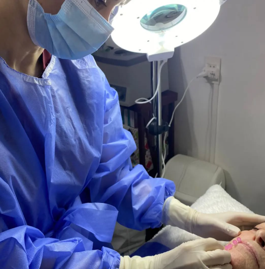 Un cirujano con mascarilla y guantes examina la cara de un paciente.