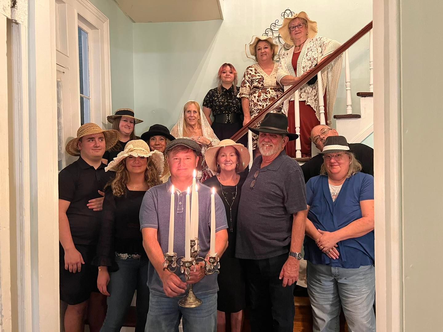 A group of people are standing on a set of stairs holding candles.