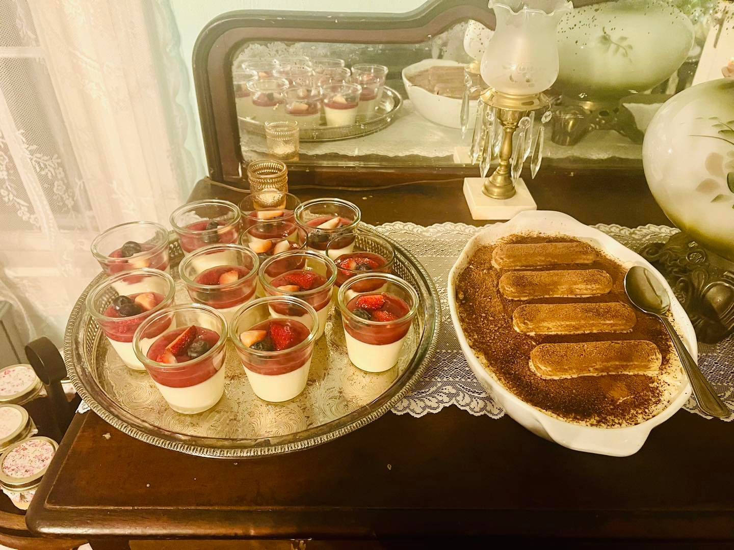A table with a tray of desserts and a bowl of tiramisu.