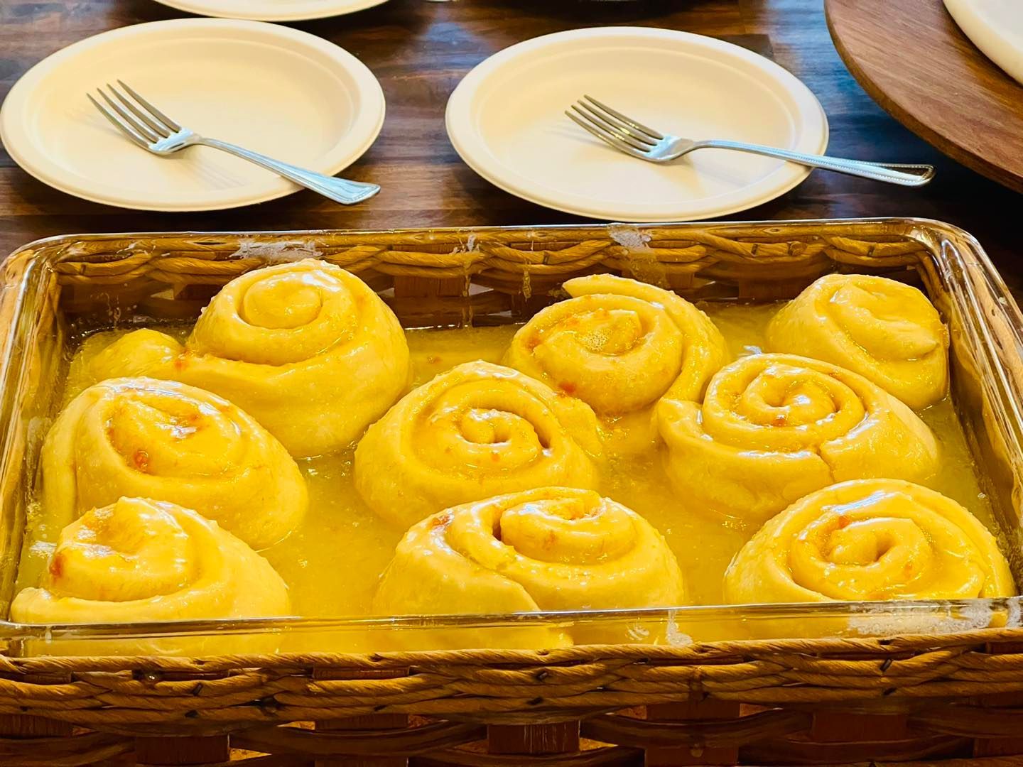 A casserole dish filled with yellow swirls and plates and forks on a table.